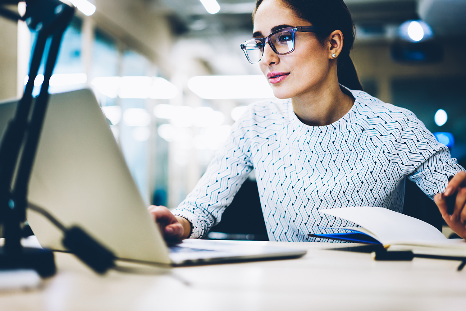 Experienced businesswoman reading publication via laptop compute