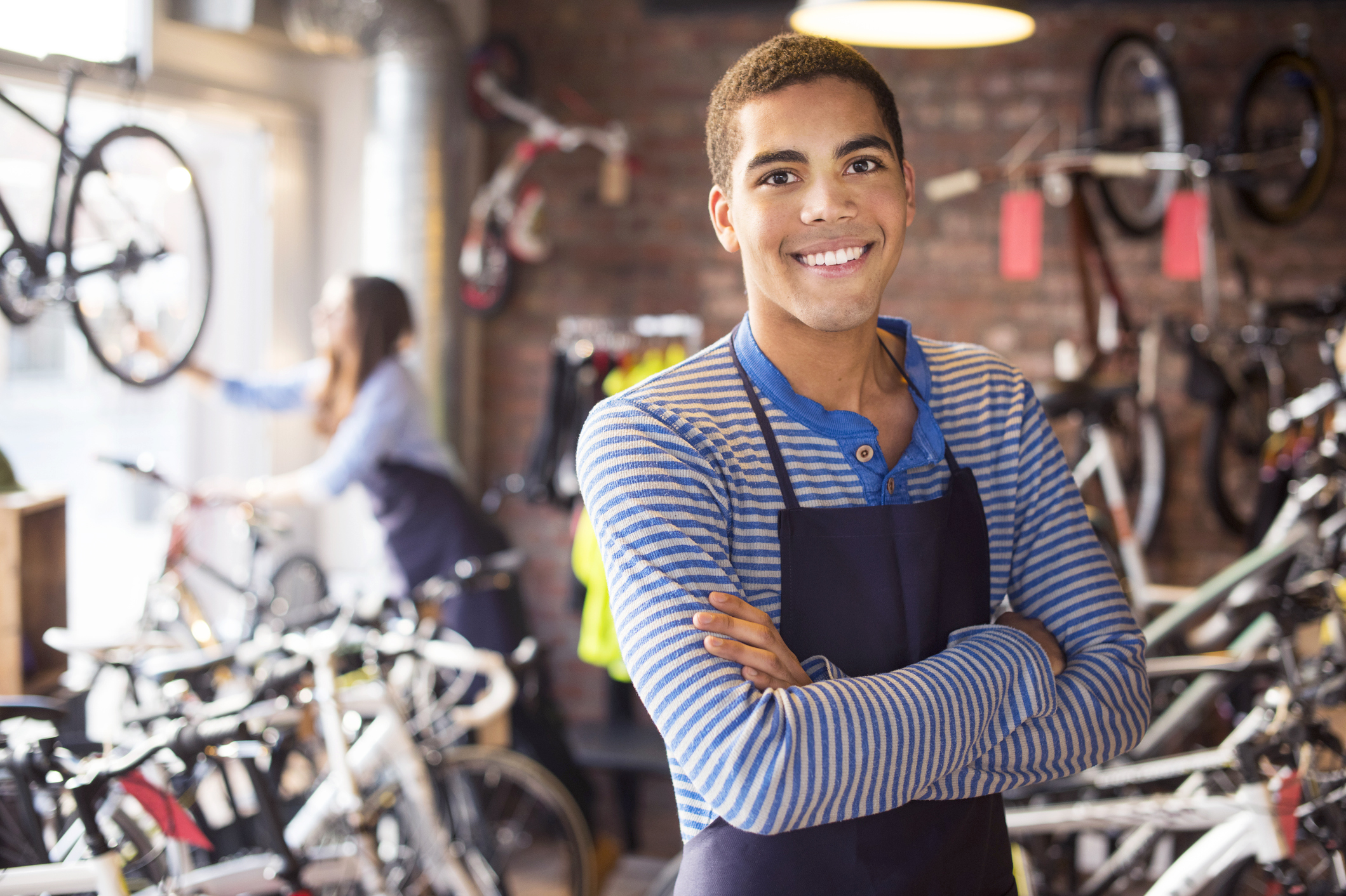 bike shop worker stands proudly in front of his stock